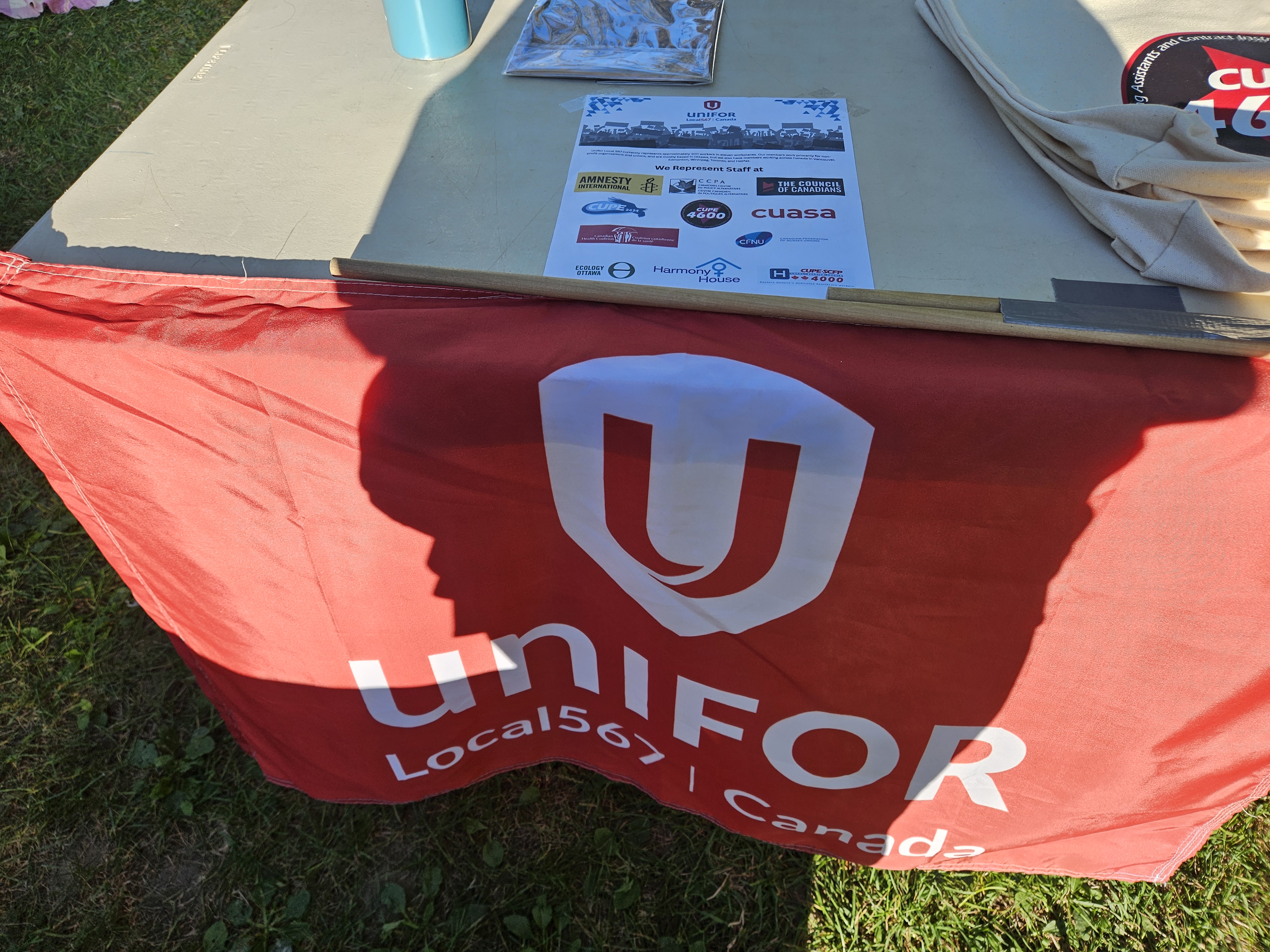 A picture of a table with a Unifor 567 flag taped to the front.