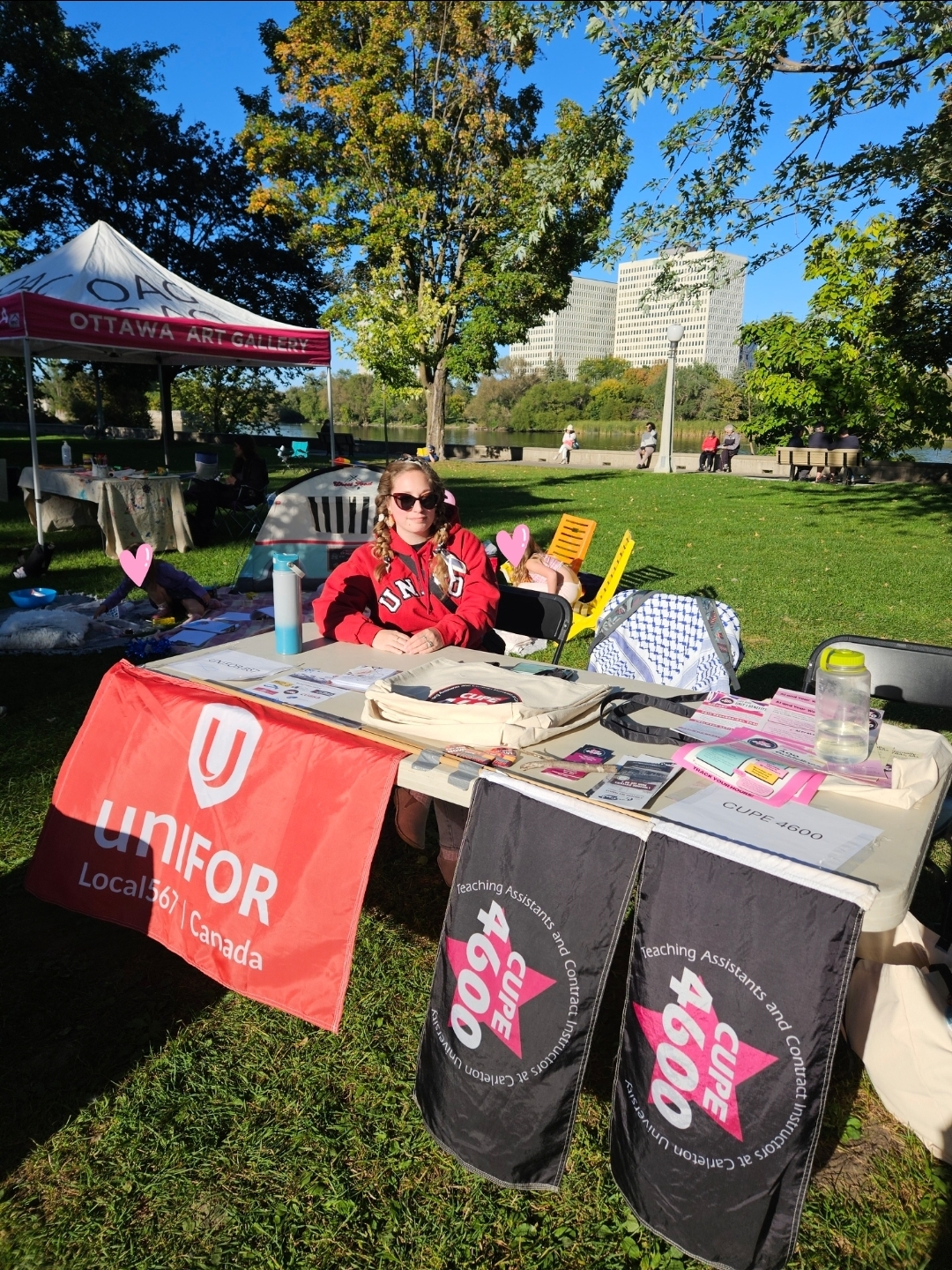 Unifor 567 Vice-President sitting at a table with a Unifor 567 flag taped to the front at Strathcona Park.